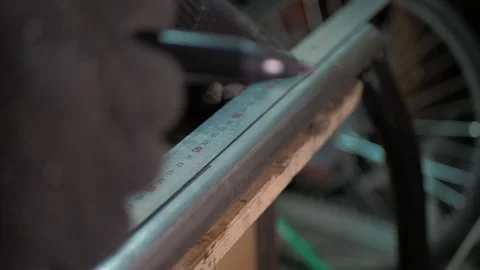 Workshop. A worker uses a steel ruler to draw a line on a pipe. Stock Footage 311759858