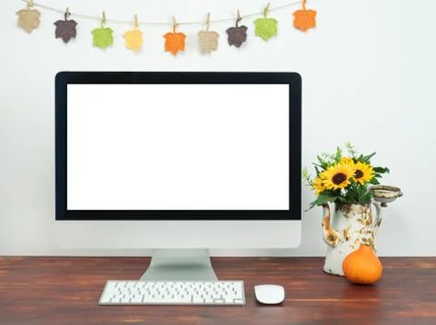 Workspace with blank computer screen and autumn decoration. Stock Photos
