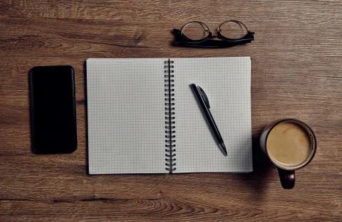 Workspace with coffee cup, phone, notepad and on old wooden table Stock-Fotos