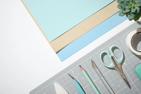 Workspace with cutting mat, scissors, craft knife, pastel papers and tools .. Stock Photos