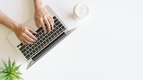 Workspace with hands typing on laptop. Flat lay, top view Stock Photos