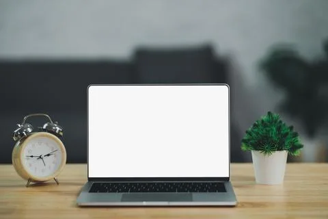 Workspace with laptop and clock on the table in co-working space. Conceptual  Stock Photos