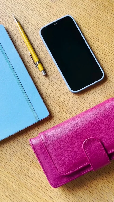 Workspace layout with phone notebook pencil and pink wallet Video stock 331772529