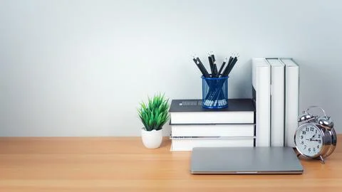 Workspace mock up white table top with laptop, Pencils, Book, Alarm clock a.. Stock Photos