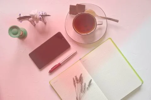 Workspace with notepad, cup of tea on a white background. Flat lay, top view Stock Photos