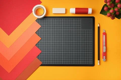 Workspace for paper crafts. Sheets of colored paper, cutting mat, pencil, kni Stock Photos