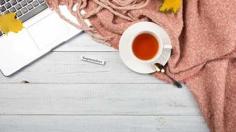 Workspace with red and yellow maple leaves, laptop, cup of tea Stock Footage 118540301