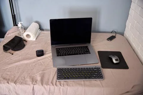 Workspace setup with laptop keyboard wireless mouse and hygiene items on be.. Stock Photos