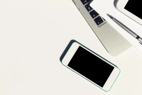 Workspace setup with modern technology including a smartphone, laptop, and pen 写真素材