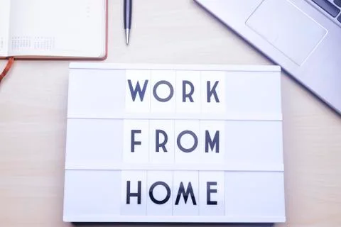 Workspace table with a lichtbox with the words WORK FROM HOME. Stock Photos