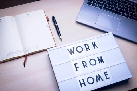Workspace table with a lichtbox with the words WORK FROM HOME. Stock Photos