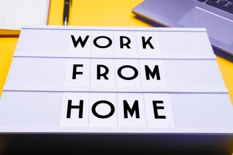 Workspace table with a lichtbox with the words WORK FROM HOME. Stock Photos