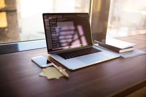 Workstation with open pc laptop computer, mobile phone and touch pad in cowor Stock Photos