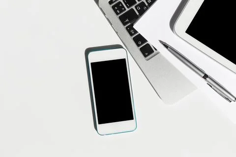Workstation setup with smartphone, tablet, and laptop on minimalist desk during Stockfoto's