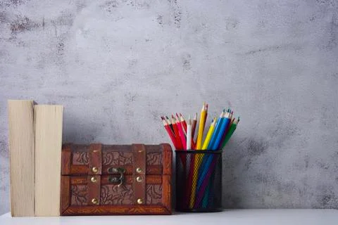 A worktable with two books, a chest of valuables and colored crayons, copy space Foto stock
