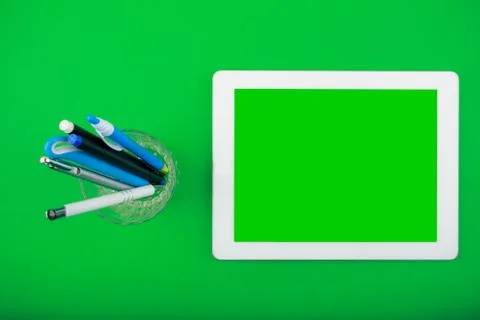 Worktop top view. white tablet with a blank screen and organiser with pens Stock Photos