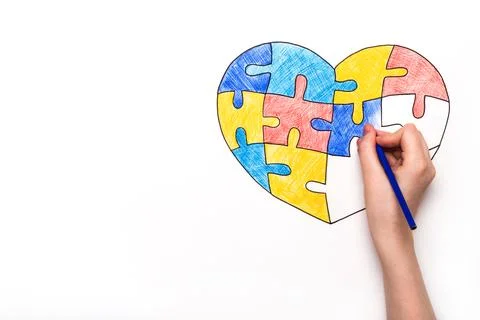 World Autism Awareness day. Children's hand draws heart from multi-colored Stock Photos