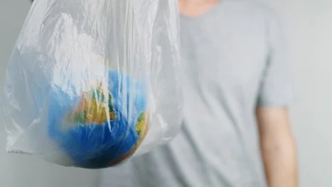 World Environment Day. Man's hands holds the earth in a plastic bag. The glob Stock Footage 121583864