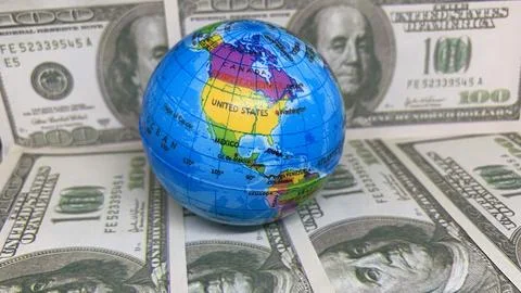 World globe resting on U.S. dollar banknotes, representing global trade, Stock Photos