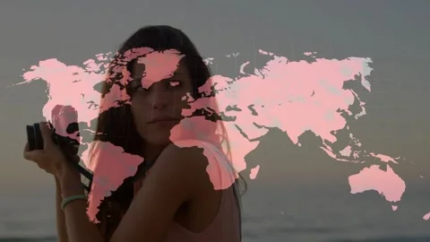World map graphic overlaying frame, woman adjusting camera, turning, smiling, Stock Footage 330463140