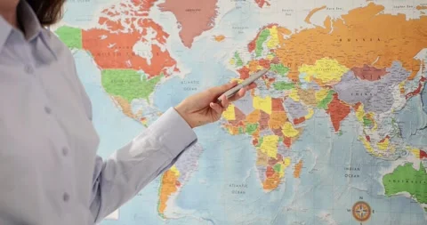World map pointer in hand of accountant outlines borders of different countries Stock Footage 252931696