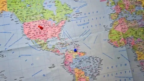 World Map printed on paper and marked USA and Venezuela with thumb pins. Stock Footage 341164443