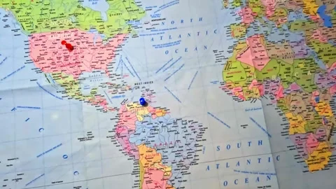 World Map printed on paper and marked USA and Venezuela with thumb pins. Stock Footage 341164582