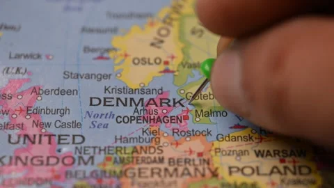 World Map Shot Featuring Green Pin Highlighting Denmark Pointed by Hand Stock Footage 333579072