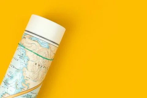 World map on the table, flat lay composition and yellow desktop background, t Stock Photos