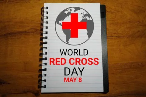 World Red Cross Day text on notebook with world map and red cross on wooden.. Stock-Illustration