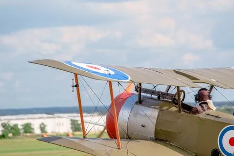 A World War I. aircraft, driven by a pilot in historical uniform. Stock Photos