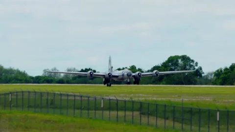 World War II B-29 bomber - with roaring engines - takes off and passes overhead Видео 154184805