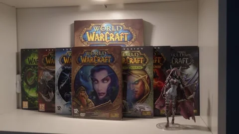 World of Warcraft game boxes displayed with figurine on shelf Stock Footage 334657461
