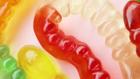 Worm shape jelly beans candies rotating. Pink background, macro Stock Footage 155282271