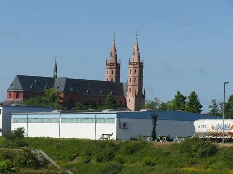 Worms Cathedral twin spires frame a blue sky above the Rhine, contrasting h.. Fotos de archivo