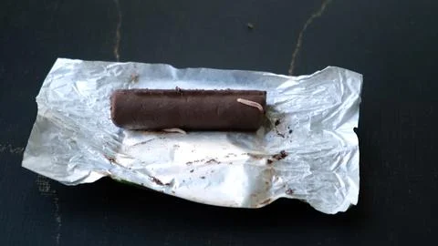 Worms crawls on chocolate candy. Crawling larvae and eggs laid on food. Not Stock Photos