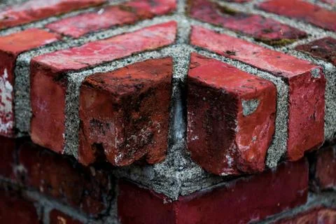 Worn aged red brick corner with a missing piece Stock Photos