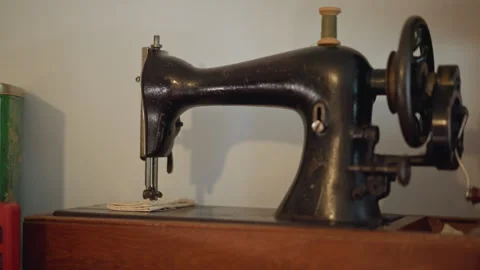 Worn black sewing machine resting on workshop workspace. Retro black stitching Stock Footage 346547625