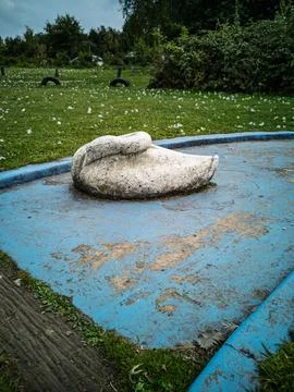 Worn blue miniature golf course obstacle in the shape of a sleeping swan Stock Photos