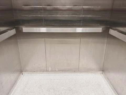 Worn Brushed Stainless Steel Elevator Interior with Handrails and Scratched  Stock Photos