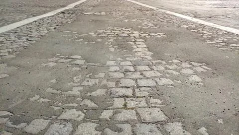 Worn Cobblestone Road Surface with White Lane Markings Stockfoto's