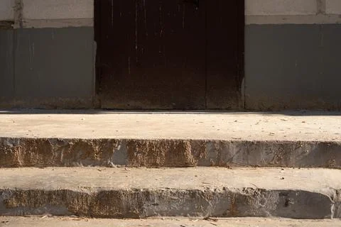 Worn concrete steps leading to a rusty metal door Stock Photos