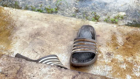 Worn Flip Flops Soaked by Rain on House Terrace Stock Footage 323860363