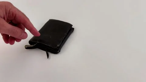 Worn Leather Wallet on White Surface as Finger Moves Into Frame Stock Footage 321118393