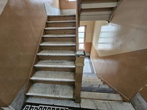 Worn Marble Staircase and Hex Mosaic Tile Floor in Old Tenement Stairwell Stock Photos