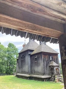 A worn, multi-sectional, conical-roofed wooden building in a grassy rural s.. Stock Photos