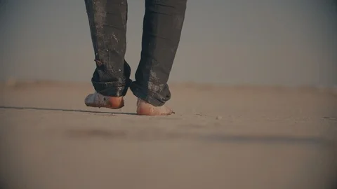 Worn out barefoot man walking in desert , making bloody footsteps before falling Vídeo Stock 104844457