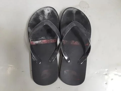 Worn-out black flip-flops Stock Photos