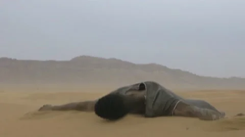 Worn-out black guy laying down on a desert sand 03 Видео 67558659