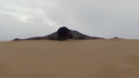Worn-out black guy laying down on a desert sand Stock Footage 67559275